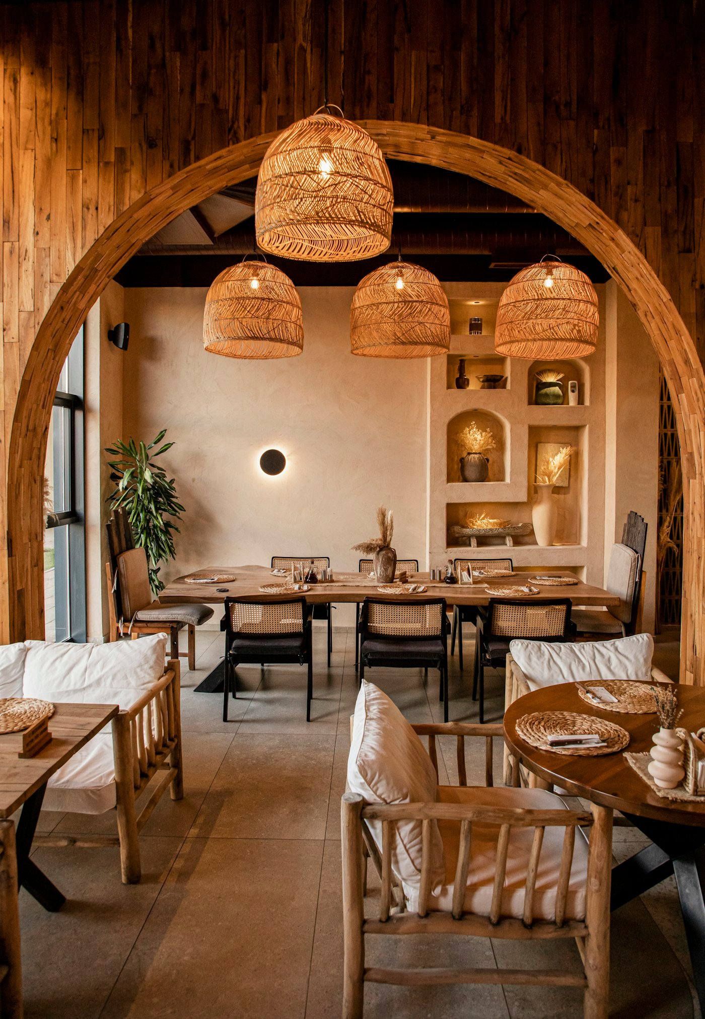 Restaurant chaleureux, suspensions en rotin sous une arche